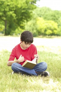boy reading in grass